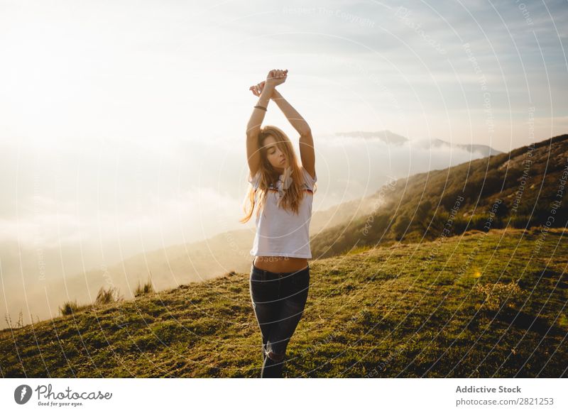 Junge Frau, die auf einem Hügel posiert. Natur genießend Freiheit Lifestyle Mensch Freizeit & Hobby Sonnenlicht Sonnenstrahlen Tag schön lieblich charmant