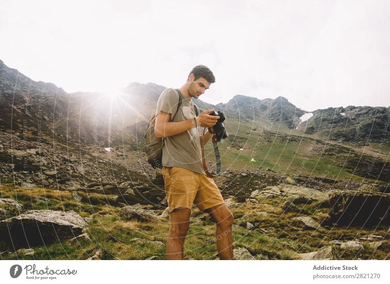 Mann beim Durchsuchen der Kamera in den Bergen Fotograf Berge u. Gebirge Fotokamera Browsen Natur Landschaft Fotografie wandern Tourist Ferien & Urlaub & Reisen