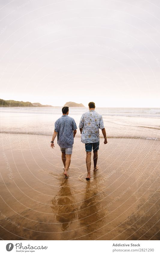 Männer, die zum Meer gehen. Mann laufen Strand Zusammensein Freundschaft Paar Homosexualität Wasser Sand Ferien & Urlaub & Reisen Jugendliche alternativ Natur