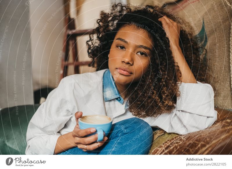 Frau trinkt eine Tasse Kaffee. schön urwüchsig schwarz Jugendliche Afrikanisch rühren Latte brünett attraktiv Mensch Beautyfotografie Erwachsene Stil niedlich