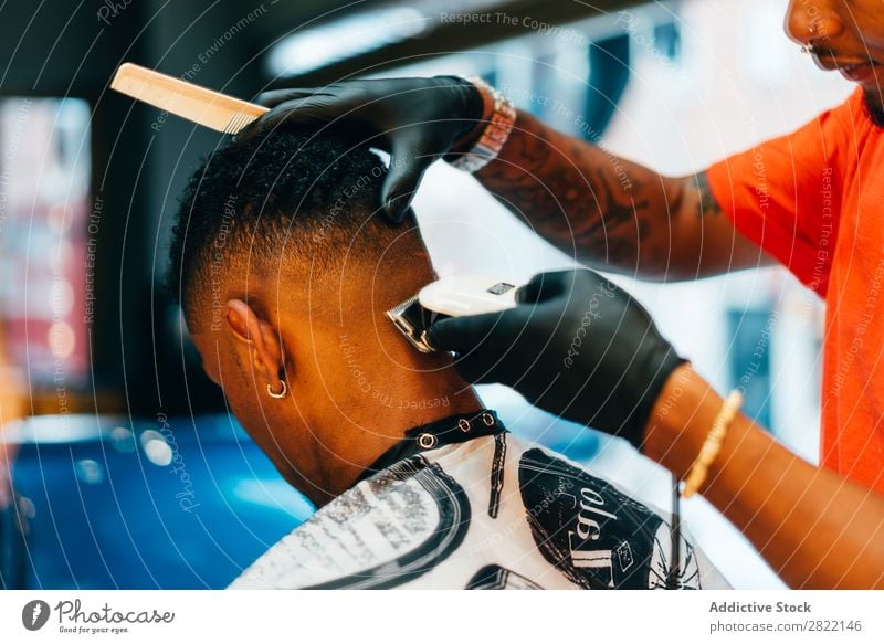 Friseur mit Pflegemaschine Friseursalon Kunde Haarkleid Behaarung Salon schwarz Mann Jugendliche Klient Haare schneiden Haare & Frisuren Fürsorge professionell
