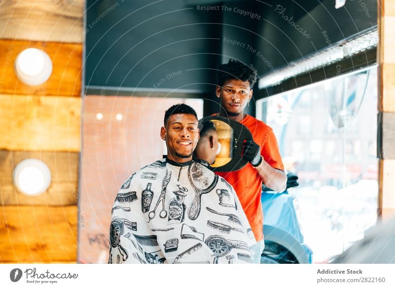 Friseur zeigt dem Kunden den Haarschnitt Friseursalon Haarkleid Behaarung zeigen Spiegel Reflexion & Spiegelung Salon schwarz Mann Jugendliche Klient