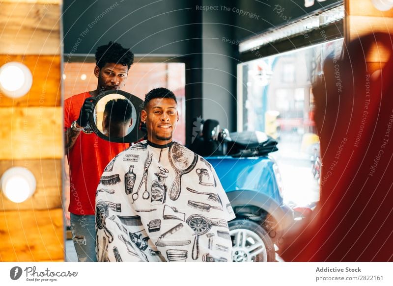 Friseur zeigt dem Kunden den Haarschnitt Friseursalon Haarkleid Behaarung zeigen Spiegel Reflexion & Spiegelung Salon schwarz Mann Jugendliche Klient