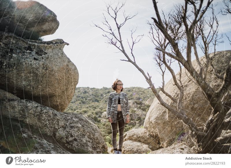 Hübsche junge Frau steht auf einer Klippe. Stil Natur Felsen Stein stehen Sonnenstrahlen Tag attraktiv schön Jugendliche Mode Schickimicki hübsch Coolness