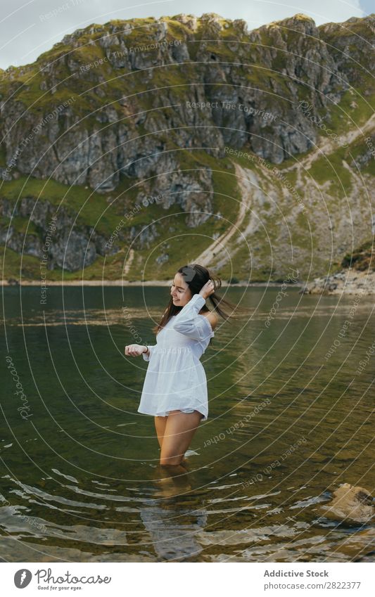 Hübsche Frau im Bergsee See Berge u. Gebirge Lächeln stehen Behaarung ausrichten berühren Hügel Halde Wasser Jugendliche Sommer Ferien & Urlaub & Reisen