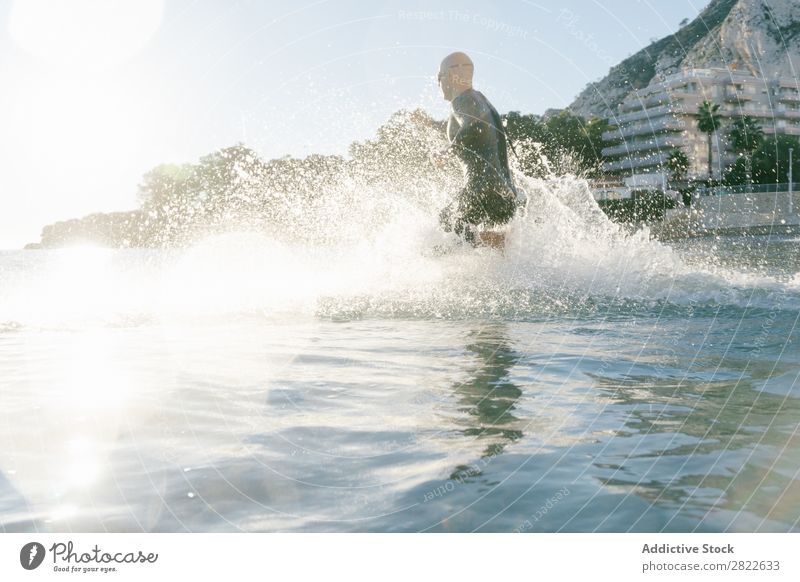 Taucher läuft ins Wasser Mann Neoprenanzug rennen Spritzer Bewegung Meer Freiheit Schwimmsportler Sportler Aktion Wassersport Freizeit & Hobby Erholung hell