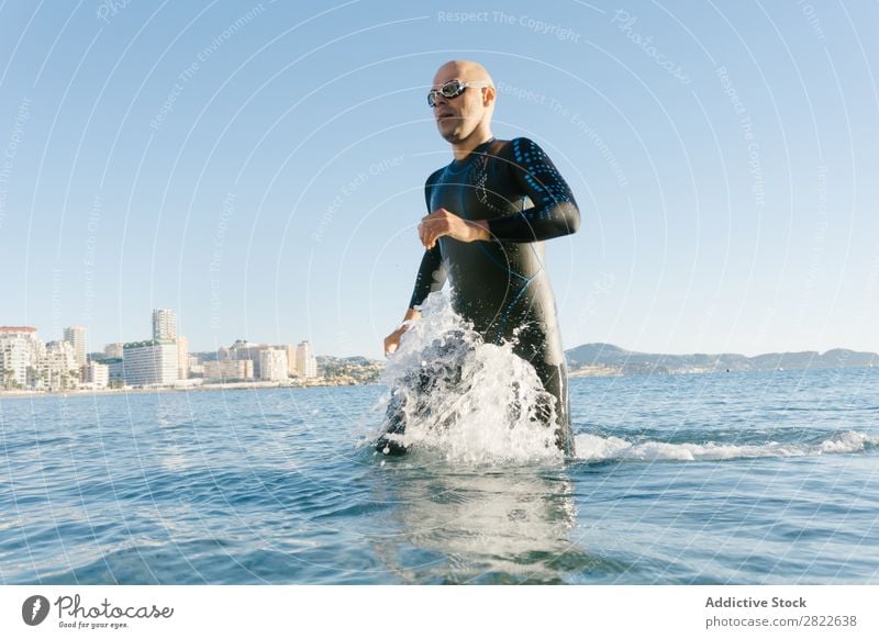 Taucher läuft ins Wasser Mann Neoprenanzug rennen Spritzer Bewegung Meer Freiheit Schwimmsportler Sportler Aktion Wassersport Freizeit & Hobby Erholung hell