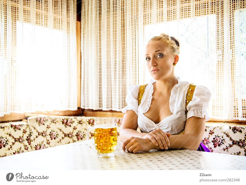 Klischee -Portrait elegant Stil Oktoberfest Jahrmarkt feminin Junge Frau Jugendliche 18-30 Jahre Erwachsene Trachtenkleid Piercing blond Hochsteckfrisur sitzen