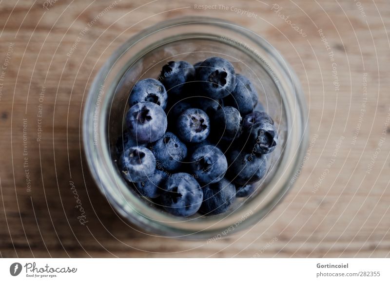 Blaue Beeren Lebensmittel Frucht Ernährung Bioprodukte Vegetarische Ernährung Diät Glas frisch Gesundheit lecker blau braun Blaubeeren Holztisch Foodfotografie