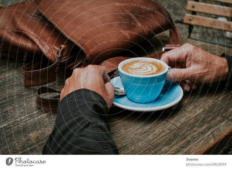 Mann mit blauer Kaffeetasse auf Holztisch Getränk Heißgetränk Latte Macchiato Espresso Lifestyle elegant Stil Mensch Hand 1 45-60 Jahre Erwachsene braun Freude