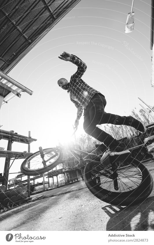 BMX-Fahrer mit Tricks Mann springen Fahrrad Sport Jugendliche Lifestyle in Bewegung Aktion extrem Schwarzweißfoto Reiter Motorradfahren üben Raser Freestyle