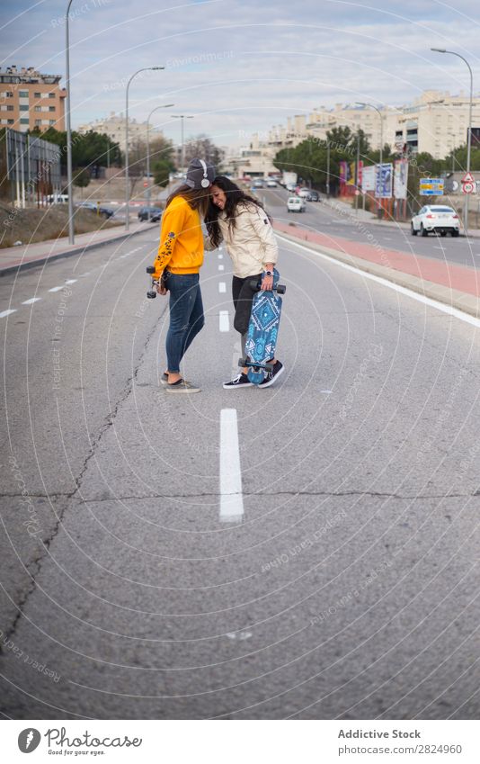 Zwei Mädchen, die auf der Straße mit Longboard spielen. Energie Frau Mensch Freizeit & Hobby Bewegung Tourist Glück Abenteuer Aktion Freiheit Model trendy
