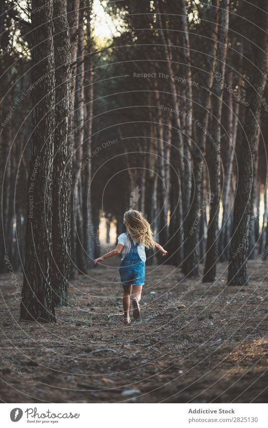Glückliches Kind beim Laufen im Wald Mädchen Fröhlichkeit Aktion rennen Freiheit Grimassen schneiden Zunge zeigen Unbekümmertheit in Bewegung Freizeit & Hobby