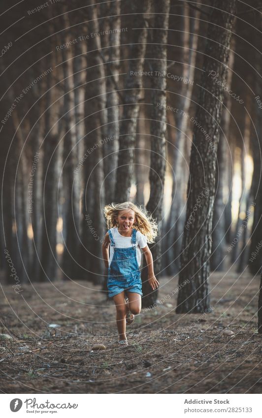Glückliches Kind beim Laufen im Wald Mädchen Fröhlichkeit Aktion rennen Freiheit Grimassen schneiden Zunge zeigen Unbekümmertheit in Bewegung Freizeit & Hobby