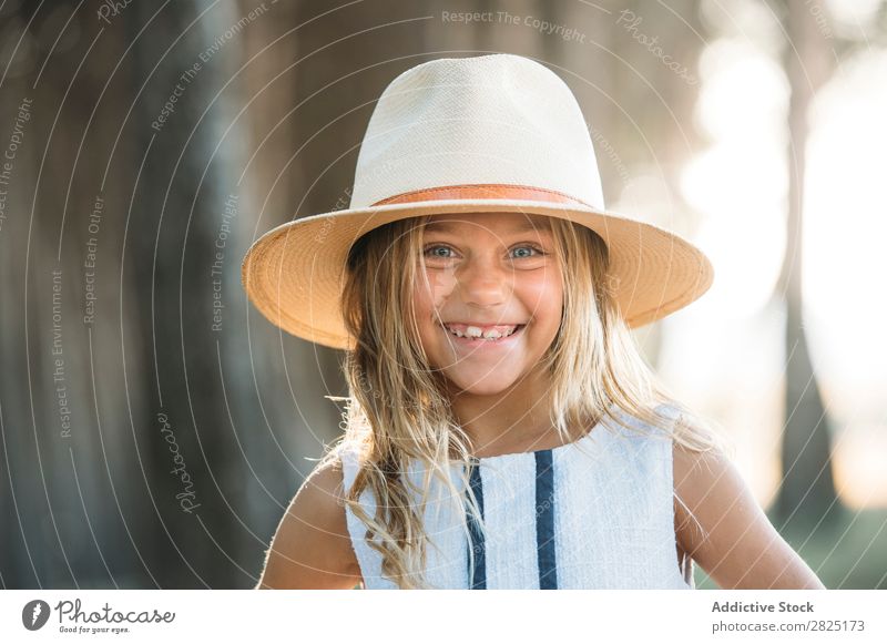 Lächelndes Kind mit Hut draußen heiter spielerisch Porträt Fröhlichkeit Körperhaltung Stil selbstbewußt Cowboy lachen Mädchen reizvoll Sommer Unbekümmertheit