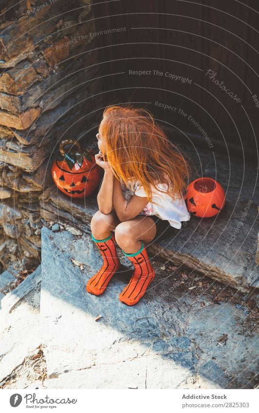Charmant auf der Veranda sitzend Mädchen Halloween Kürbis Gast Tradition Dekor Design Ferien & Urlaub & Reisen Herbst Festspiele Kind Kindheit Fröhlichkeit