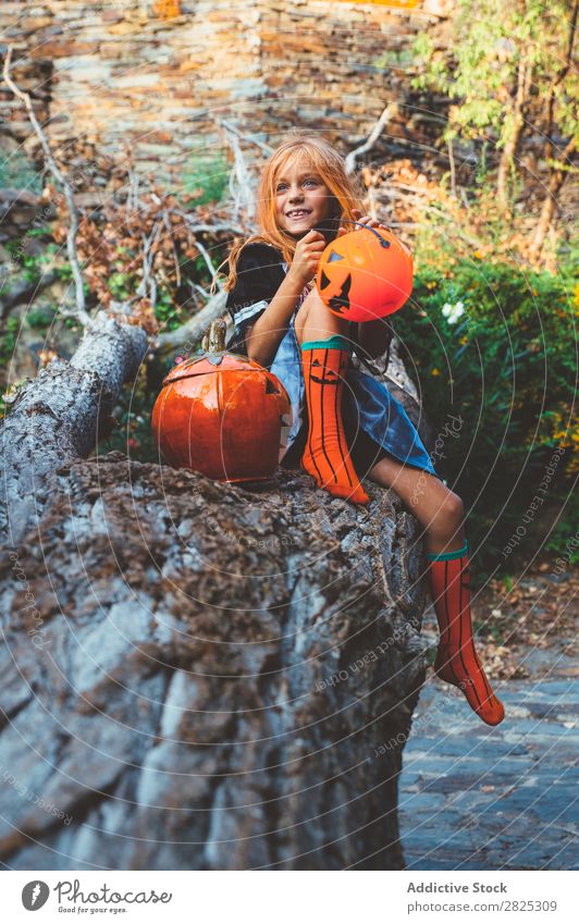 Ausdrucksstarkes Kind im Kostüm, das auf einem Baum posiert. Mädchen Natur Halloween spielerisch Körperhaltung Feste & Feiern ausgestreckt Baumstamm schreien