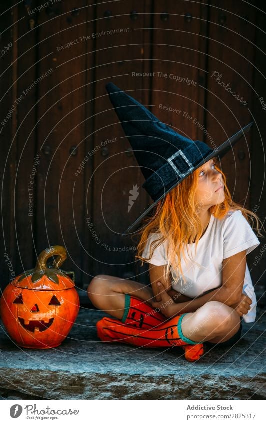 Liebenswertes Mädchen, das auf der Veranda posiert. Halloween so tun, als ob erschrecken Körperhaltung Porträt heiter Haus Kostüm Feste & Feiern Tradition