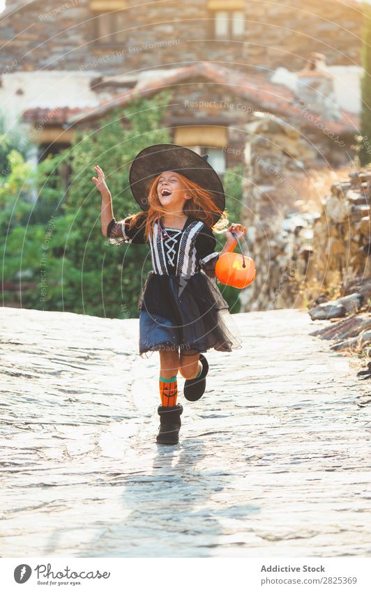 Lachendes Mädchen im Kostüm in der Straße Halloween spielerisch Gefühle Feste & Feiern Verstand schreien lachen Hexe Festspiele Tradition Ausdruck Gast Eimer