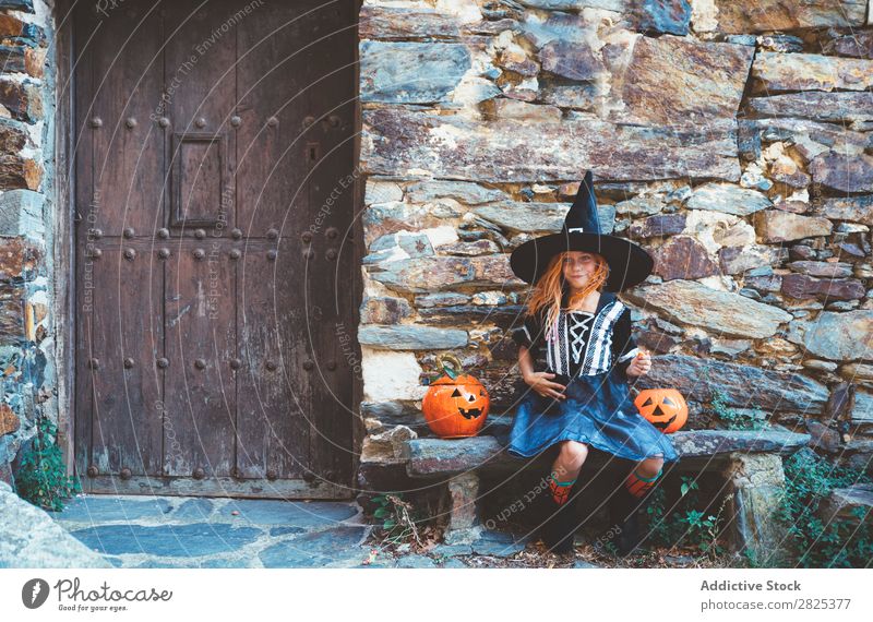 Kleines Mädchen in Hexenkostüm auf der Bank sitzend Halloween Süßwaren Hundefutter Ferien & Urlaub & Reisen Entertainment Festspiele Jahreszeiten Kostüm