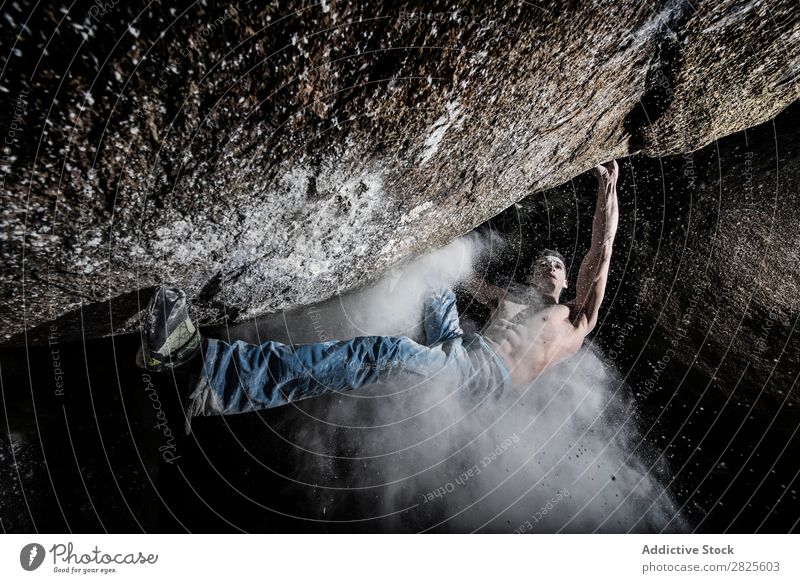 Ein Mann, der aus Magnesium auf den Felsen klettert, Berg in der Dämmerung. Kreativität Mensch Kreide Klettern stark sportlich Entscheidungen Energie Finger
