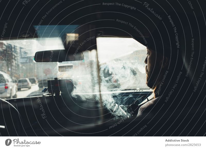 Mann im Auto sitzend Rauchen Taxi Fahrzeug Hut bärtig Zigarette selbstbewußt ernst Straße brutal Vollbart Mensch Großstadt Schickimicki Erwachsene lässig