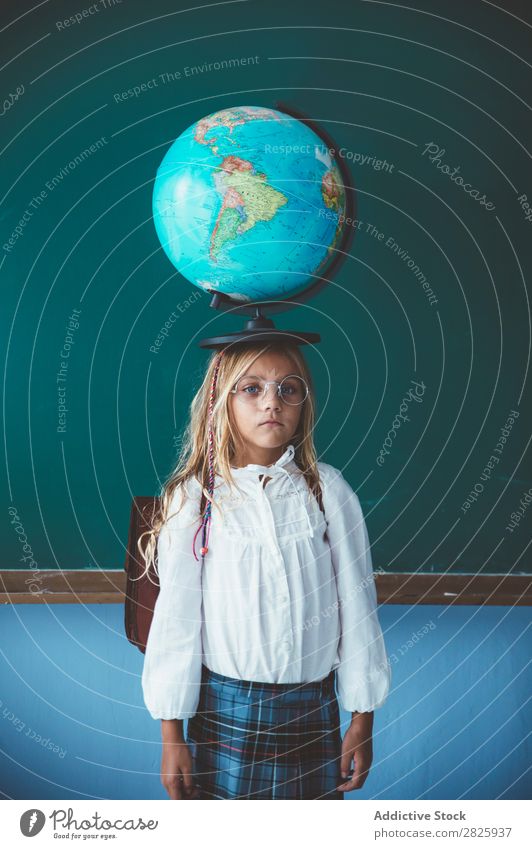 Schülermädchen posiert mit Globus Mädchen Klassenraum Geografie niedlich Bildung Schule Schulklasse Jugendliche lernen Kind Schulunterricht Pupille Wissen