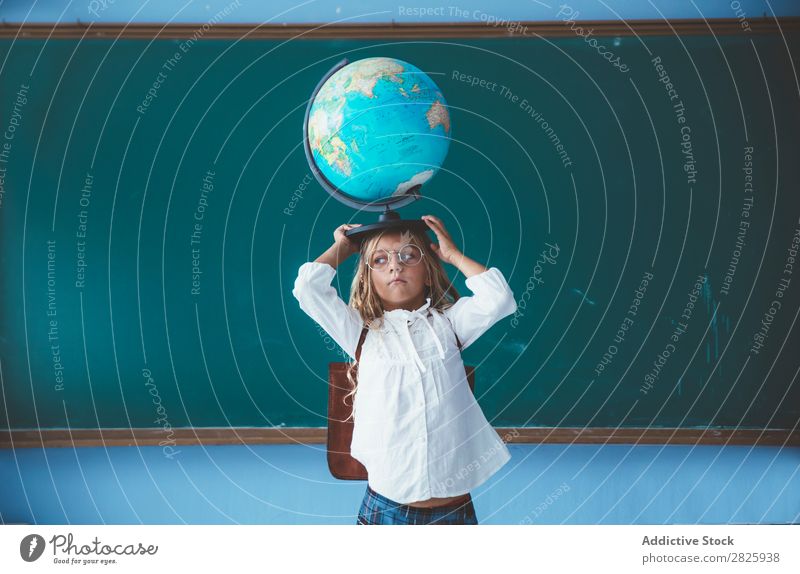 Schülermädchen posiert mit Globus Mädchen Klassenraum Geografie niedlich Bildung Schule Schulklasse Jugendliche lernen Kind Schulunterricht Pupille Wissen