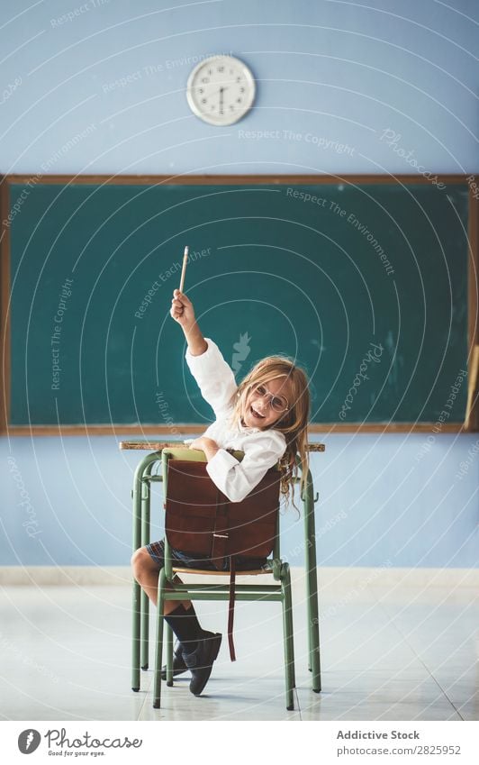 Lächelndes Mädchen mit Bleistift im Unterricht Klassenraum Tafel sitzen Blick in die Kamera Glück heiter hochreichen niedlich Bildung Schule Schulklasse Schüler