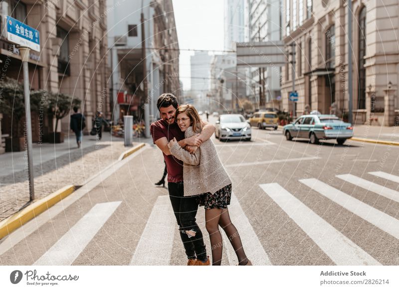 Schönes Paar, das sich auf dem Zebrastreifen umarmt. Umarmen Straße Großstadt laufen schön Zusammensein Glück Lifestyle Mann Mädchen Frau Stadt Fußgänger
