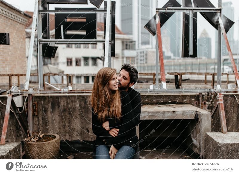 Schönes Paar auf dem Dach mit tollem Blick auf die Stadt auf Bac. heiter Dachterrasse Umarmen Großstadt Liebe sitzen Skyline Architektur Liebesgeschichte Freude