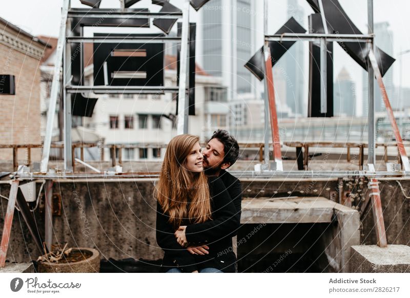 Schönes Paar auf dem Dach sitzend heiter Dachterrasse Umarmen Großstadt Liebe Skyline Architektur Liebesgeschichte Stadt Freude Zusammensein Glück Jugendliche 2