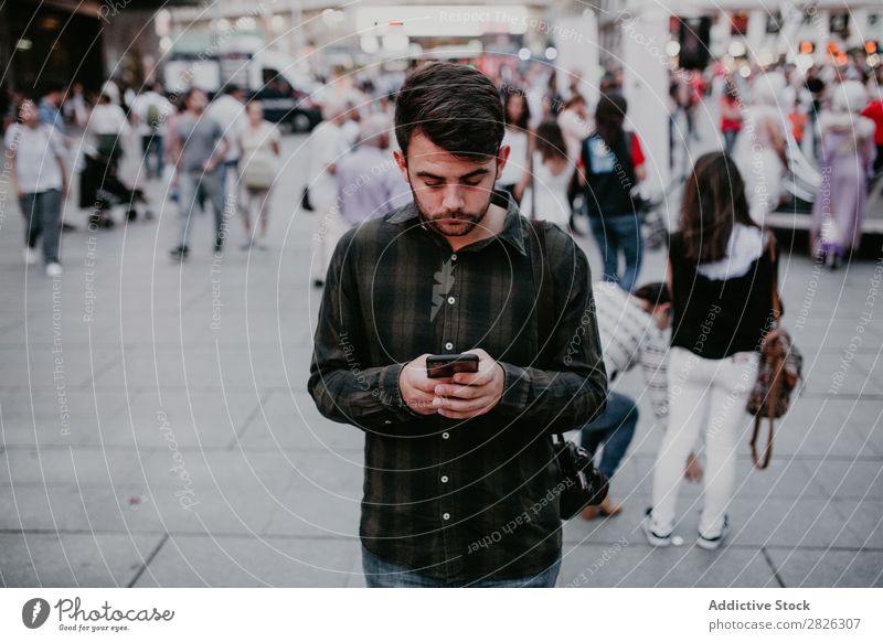 Mann mit Smartphone auf der Straße PDA lässig stehen Browsen benutzend Surfen Großstadt Telefon Mobile Lifestyle Stadt Jugendliche Fürsorge Denken besinnlich