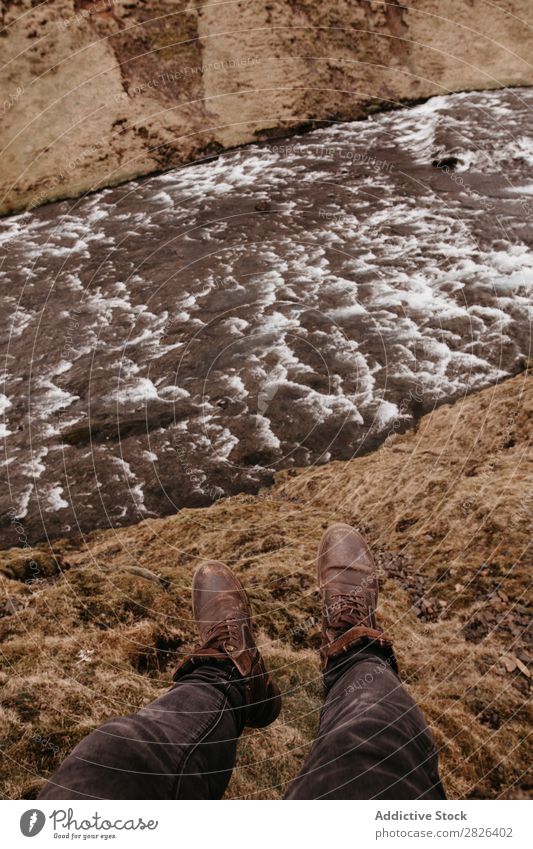 Mann auf Fels mit einem Fluss, der unten fließt. Höhe Landschaft extrem Island Felsen Aussicht Berge u. Gebirge Abenteuer Tourist Top Natur Wildnis Altimeter