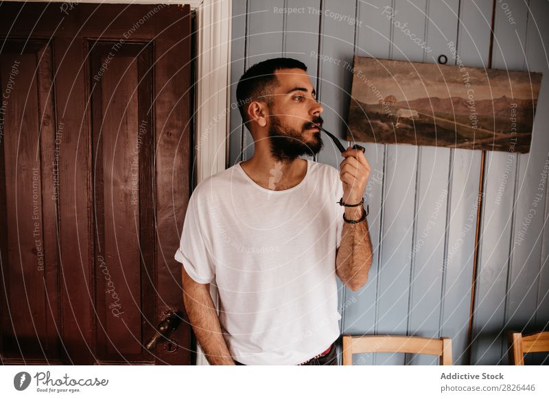 Mann raucht Pfeife innen Schickimicki Stil Erwachsene Haus Island Tabak altehrwürdig Rauchen bärtig Körperhaltung Sucht elegant lässig klassisch Rauchmaschine