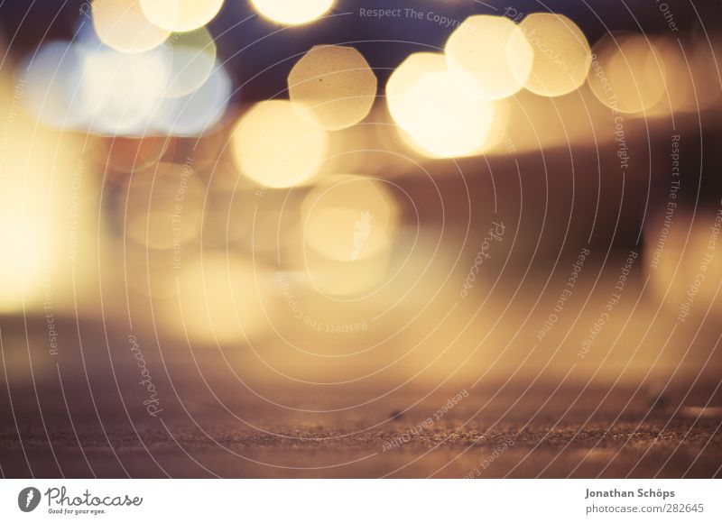 urbanes Bokeh Hintergrundbild an einer Straße bei Nacht mit Autoverkehr Nachtleben positiv braun gelb gold Unschärfe Licht Lichterscheinung Lichtermeer Stadt