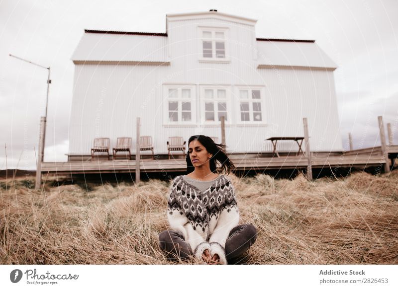 Frau, die auf dem Hintergrund des Hauses posiert. wohnbedingt Island Natur ländlich Terrasse heimwärts Landschaft natürlich wehendes Haar Ebene Bauernhof Wind