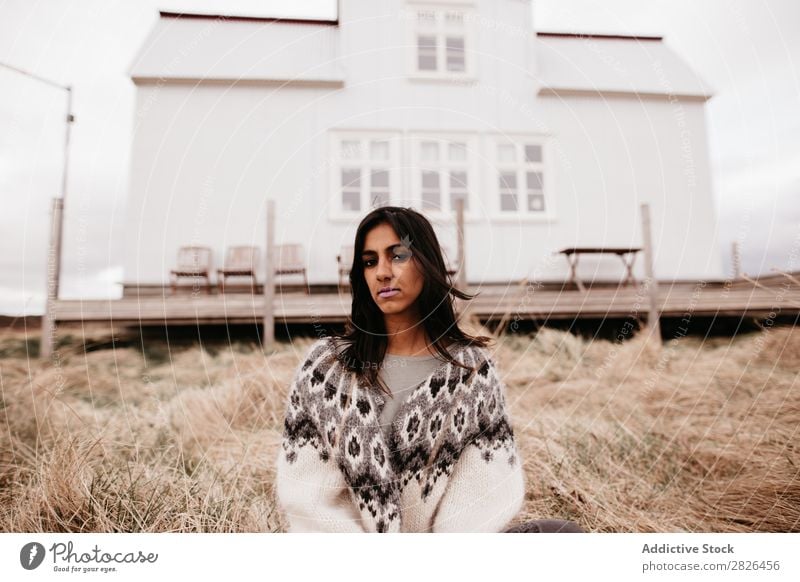 Frau, die auf dem Hintergrund des Hauses posiert. wohnbedingt Island Natur ländlich Terrasse heimwärts Landschaft natürlich wehendes Haar Ebene Bauernhof Wind