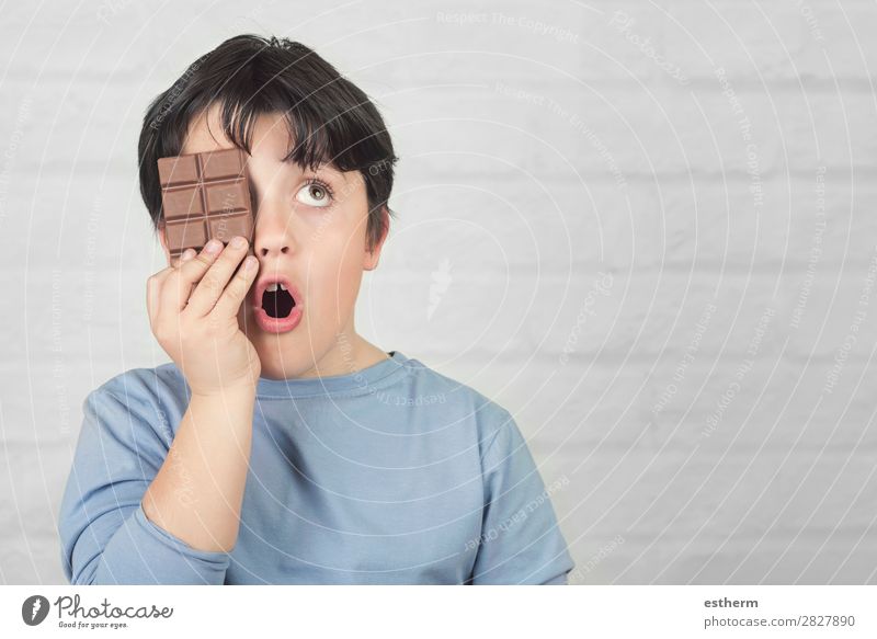 Kind, das ein Auge mit einem Schokoriegel bedeckt. Dessert Süßwaren Schokolade Ernährung Essen Diät Lifestyle Freude Übergewicht Mensch maskulin Kindheit 1