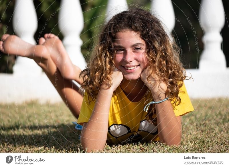 liegend und spielend mit ihren Beinen Freude Glück schön Gesicht Sommer Sonne Garten Erfolg Mensch Frau Erwachsene Natur Gras T-Shirt blond Lächeln lachen