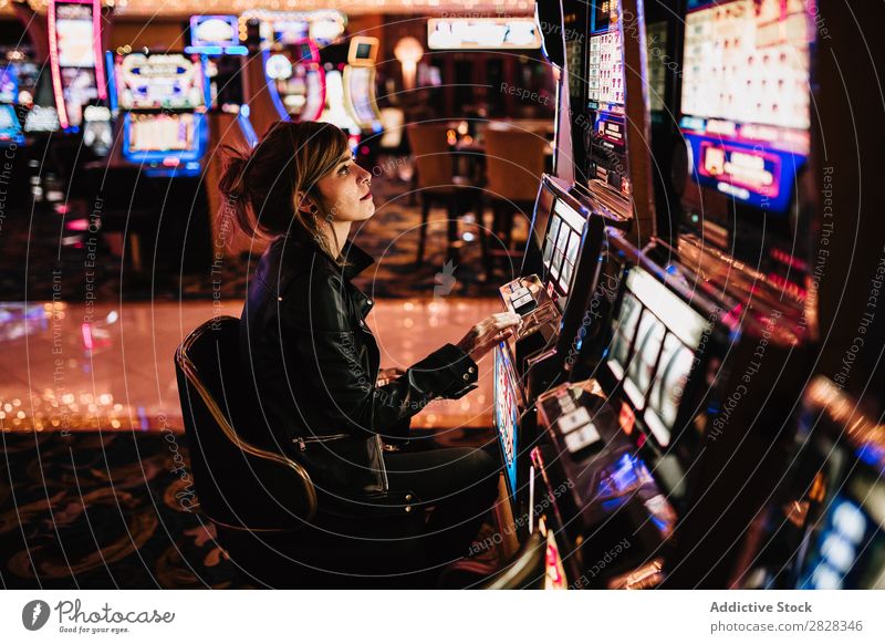 Frau spielt Spielautomat Glücksspiel Kurhaus Spielen Risiko Spieler Erfolg Glücksspieler glücklich Nachtleben Vermögen Aufregung Gelegenheit Nachtclub Vegas