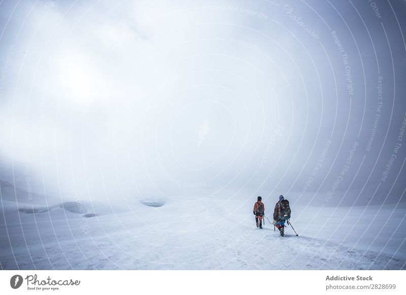 Menschen, die im Schnee laufen. Schneefälle Trekking Gerät Entdecker Ebene Rucksacktourismus Wetter Altimeter Tourismus Jahreszeiten Errungenschaft Sport