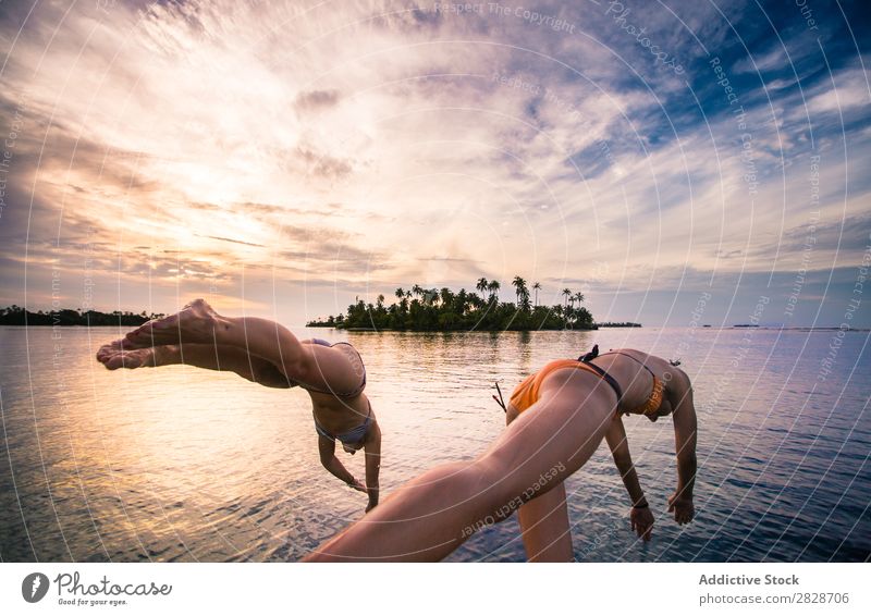 Frauen, die in das Wasser des Ozeans eindringen. Meer springen Ferien & Urlaub & Reisen in Bewegung Sommer Freiheit Strand Freizeit & Hobby Schwimmsport Energie