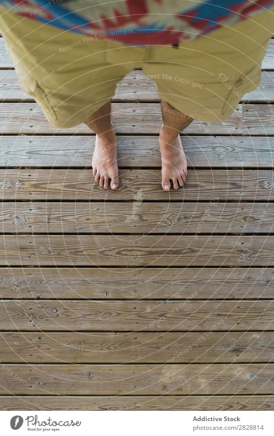 Männerfüße auf Holzboden Mann Fuß Etage stehen Beine Barfuß Strandbekleidung Lifestyle Mensch Schiffsplanken Holzplatte heimwärts anhaben rau abstrakt