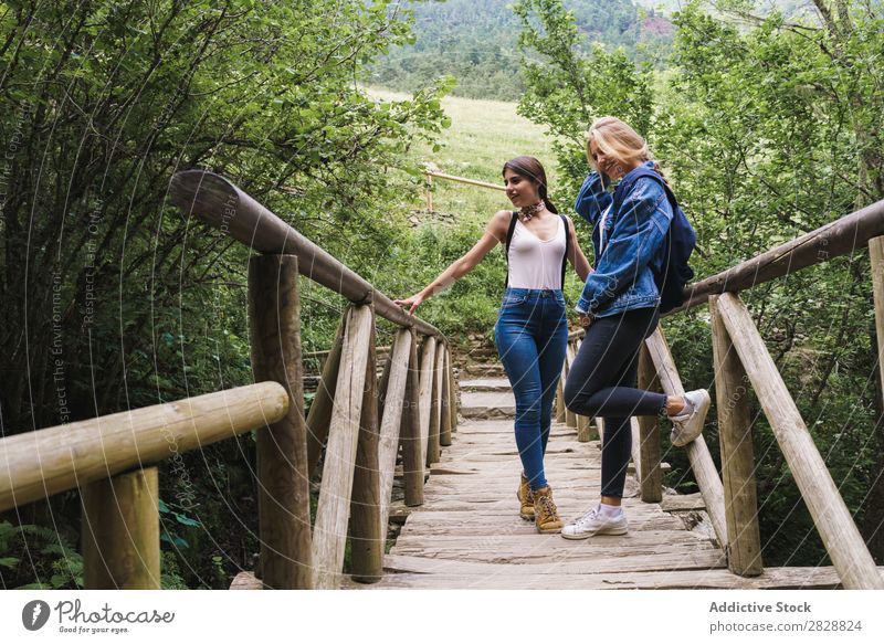 Hübsche Frauen, die auf der Brücke stehen. Holz Natur Mensch Sommer Wasser schön Beautyfotografie Ferien & Urlaub & Reisen Fröhlichkeit Jugendliche Mädchen
