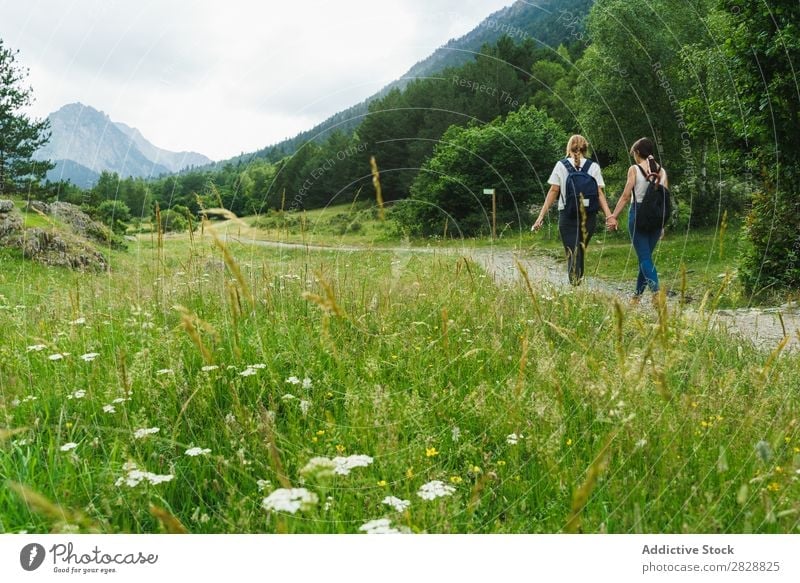 Frauen, die auf Landstraßen gehen laufen Straße ländlich Händchenhalten Freundschaft Rucksack Natur Mädchen Jugendliche schön Ferien & Urlaub & Reisen Tourismus