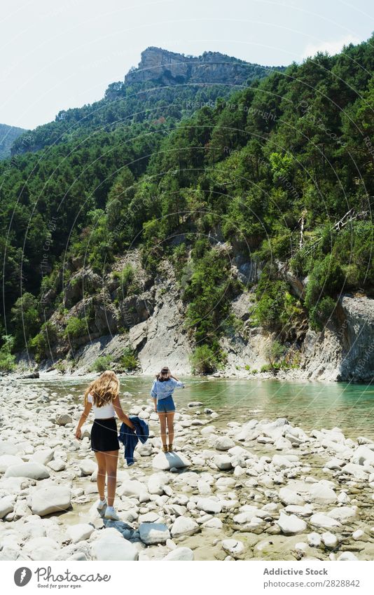 Frauen, die auf Felssteinen laufen. Freundinnen Sommer Berge u. Gebirge Tourismus Freiheit lgbt Felsen Jugendliche Paar Fröhlichkeit strömen Natur Außenaufnahme