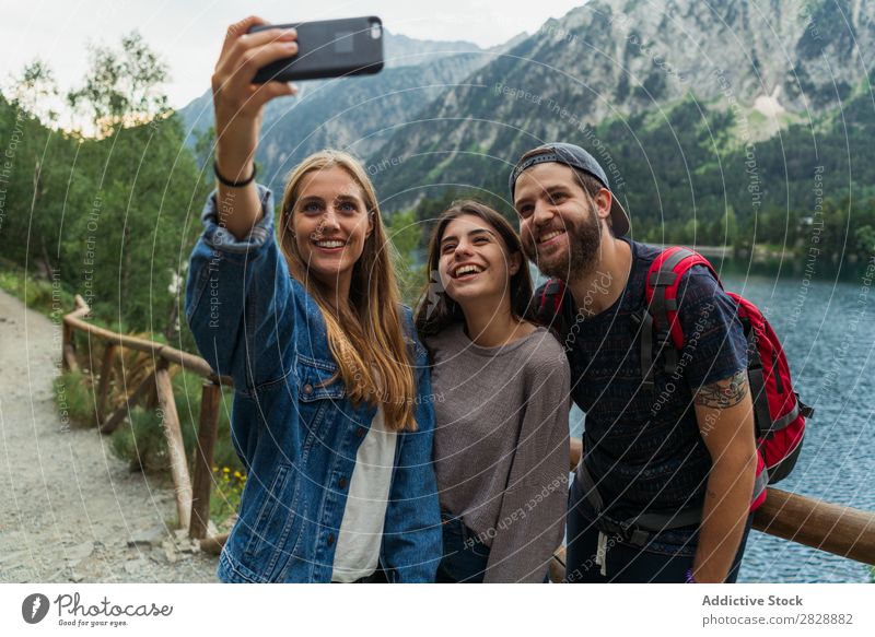 Freunde, die in den Bergen Selfie machen. Frau Mann Berge u. Gebirge laufen PDA nehmen Zusammensein Lächeln wandern See Wasser umarmend heiter Glück