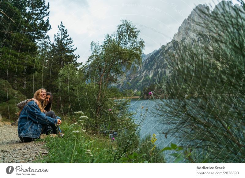 Fröhliche Frauen am See sitzend Berge u. Gebirge Lächeln heiter Zusammensein Glück lachen wandern Wasser umarmend Ferien & Urlaub & Reisen Abenteuer Tourist