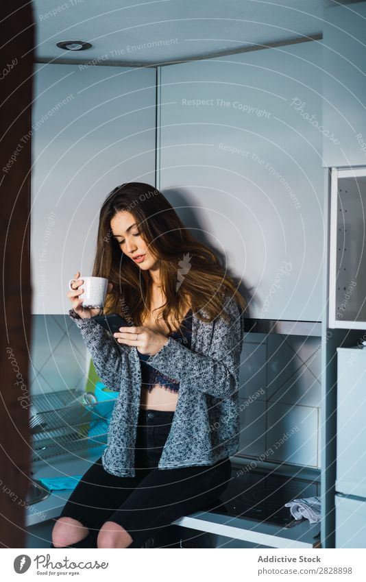 Schönes Modell mit Tasse Kaffee und Smartphone Frau heimwärts Kuscheln träumen Menschliches Gesicht Körperhaltung besinnlich Fürsorge Lifestyle Haus lässig